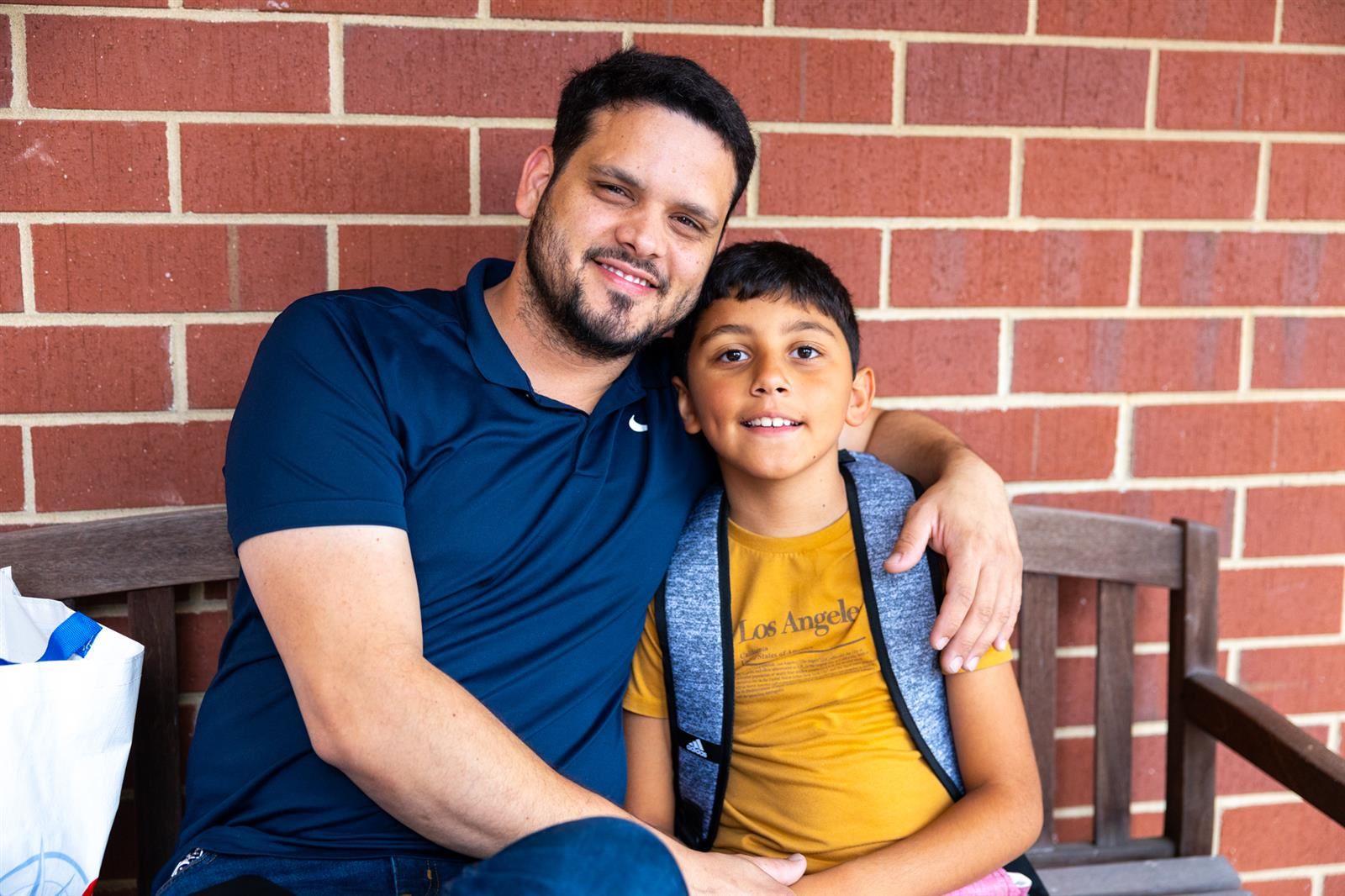 dad and boy sitting on a bench